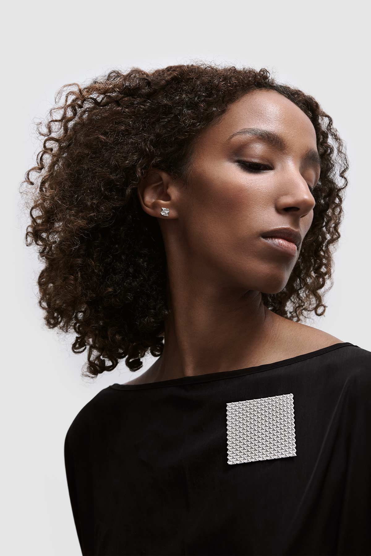 Schlichter Ohrstecker und große Brosche der Serie DX  von Fine Principles aus Silber — nachhaltiger, hochwertiger und zeitloser Schmuck für Frauen und Männer.