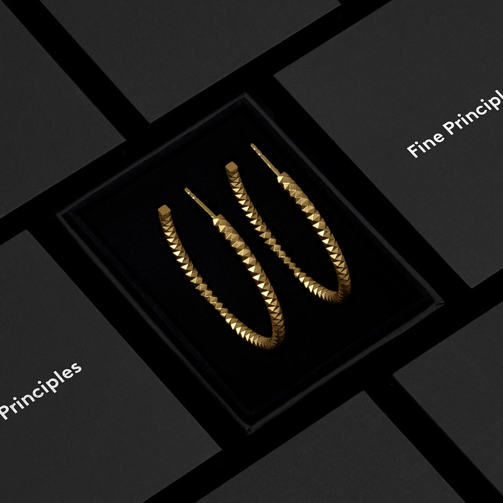 Elegant-facettierte Kreolen XFCE10242L mit 1024 Facetten, nachhaltig gefertigt aus zertifiziert recyceltem 750 Gold oder 935 Silber — moderner Schmuck von Fine Principles, stilvoll verpackt in einer schwarzen Box.