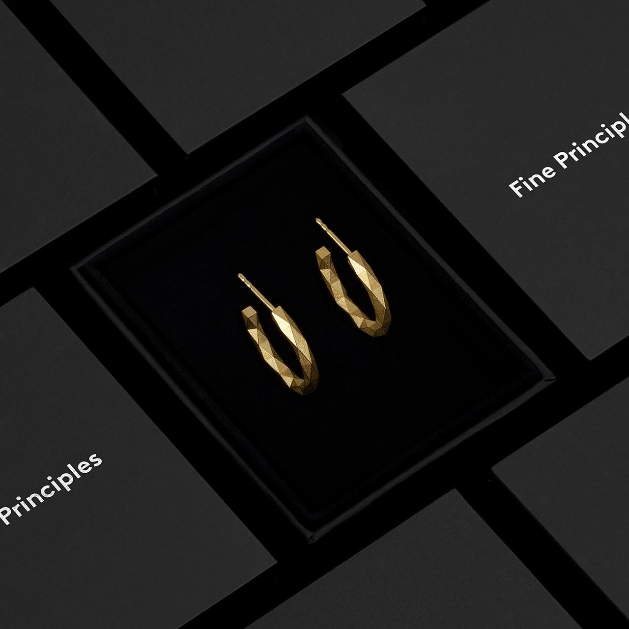 Nachhaltige Kreolen mit minimalistischen 128 Facetten, Modell XFCE1282M, aus zertifiziertem 935 Silber oder 750 Gold — exklusiver Berliner Schmuck von Fine Principles, elegant inszeniert im schwarzen Etui.