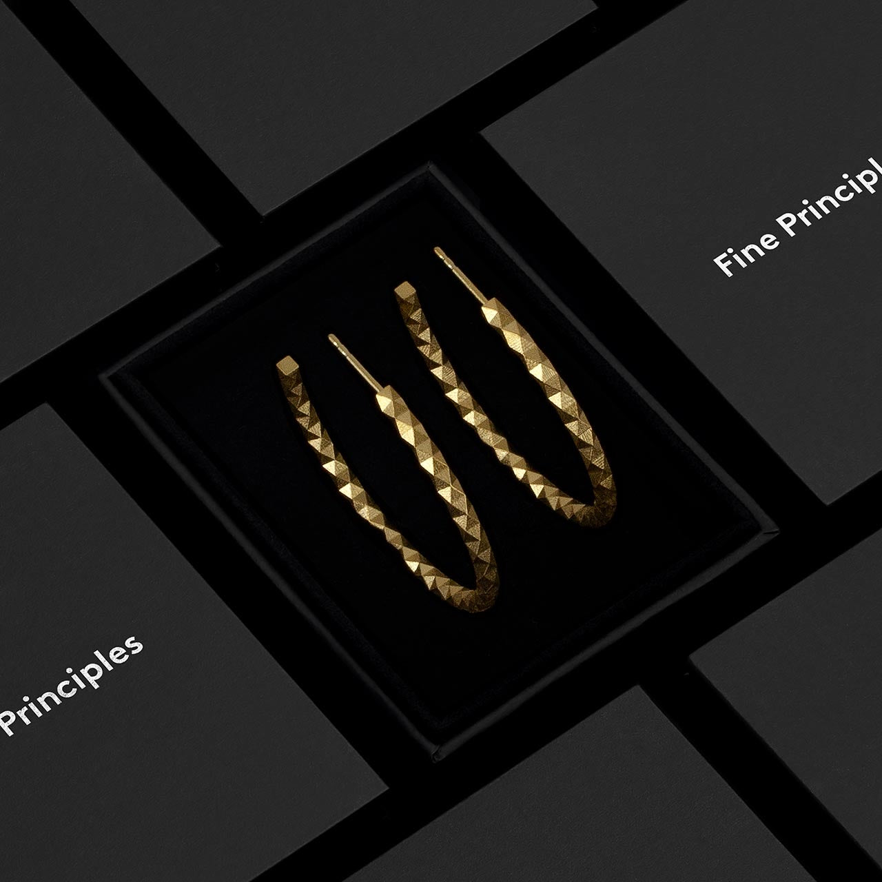 Große Kreolen XFCE2562L mit 512 unpolierten Facetten aus recyceltem 935 Silber oder 750 Gold — minimalistischer, geometrischer und nachhaltiger Schmuck von Fine Principles aus Berlin, stilvoll präsentiert im schwarzen Etui.