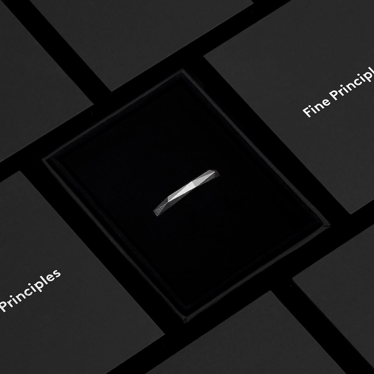 Moderner Ring XFRI642 mit klarer Geometrie, 64 Facetten — gegossen aus recyceltem Silber oder Gold, minimalistisch inszeniert im schwarzen Etui von Fine Principles Berlin.