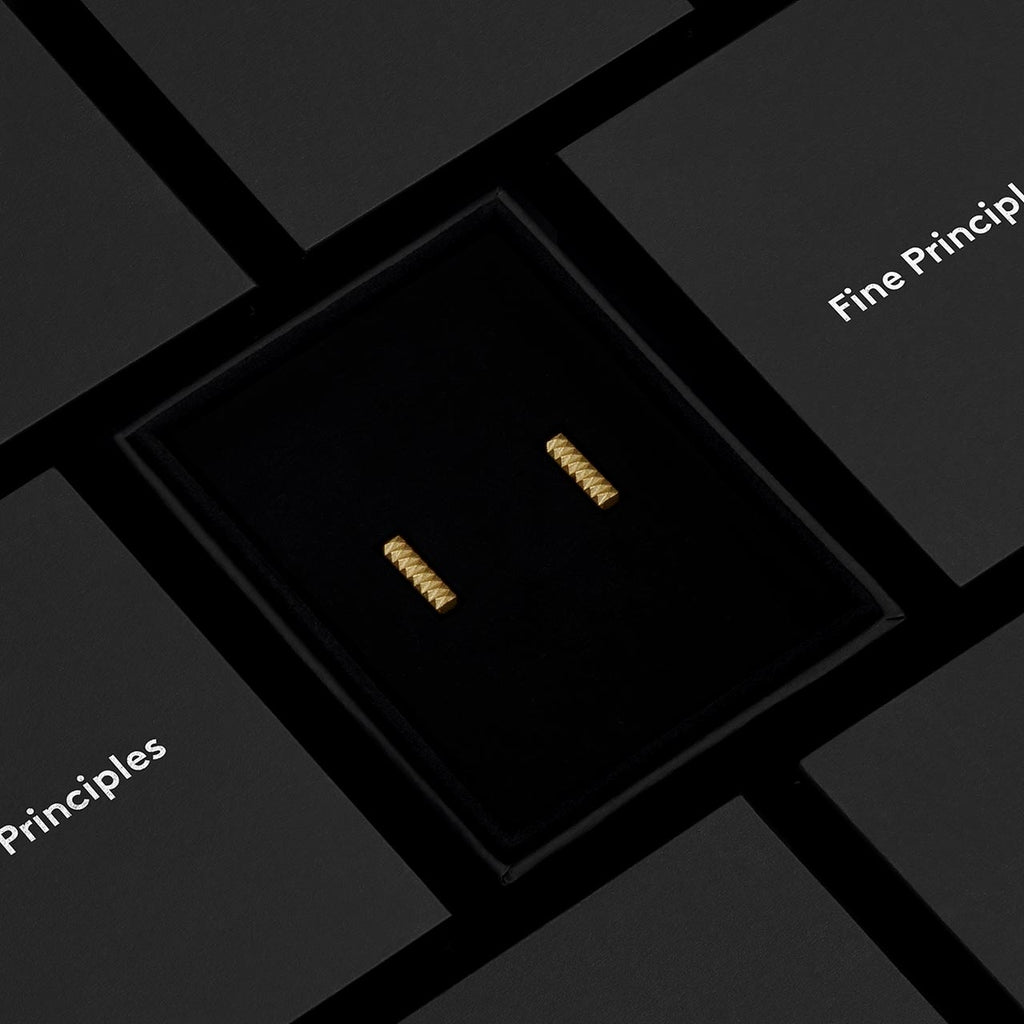 Moderne Stabohrringe XFBE1282S mit 128 Facetten, nachhaltig gefertigt aus recyceltem Gold oder Silber — modernes Design von Fine Principles, hochwertig verpackt in einer schwarzen Schmuckbox.